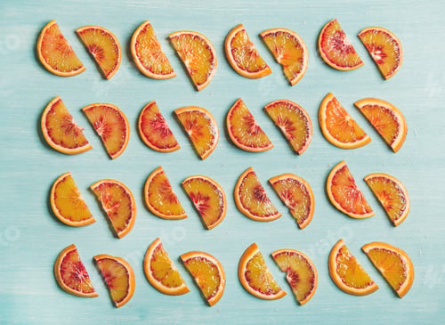 Preview: Fresh juicy blood orange slices placed in rows, blue background