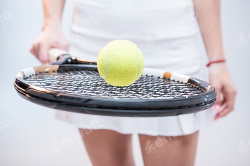 Preview: Close-up partial view of female tennis player holding racquet and ball isolated on white
