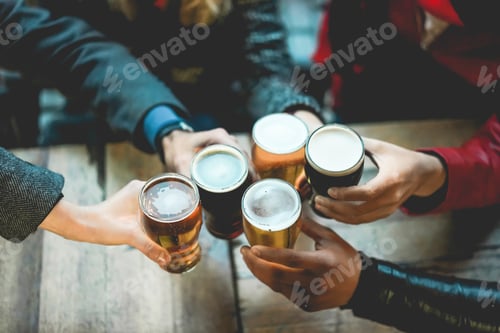 Preview: Young group of people having fun cheering with beer outdoor at bar restaurant
