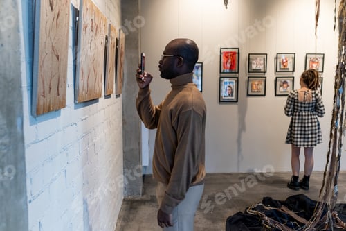 Preview: Man photographing artwork on the phone