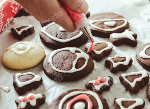 Preview: Man’s hand piping icing on gingerbread cookies
