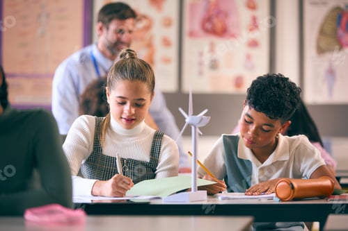 Preview: Secondary Or High School Students Studying Wind Turbines In Science Class With Teacher In Background