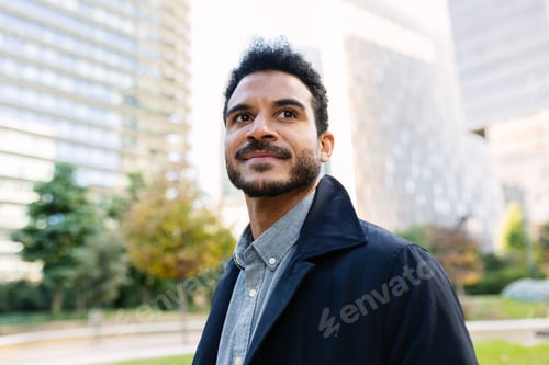 Preview: Portrait of young adult Latin American businessman looking away outdoors