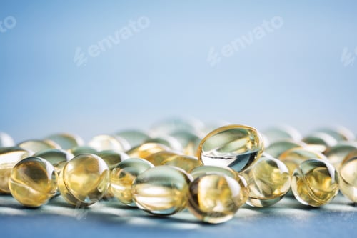 Preview: Bunch of vitamin D capsules laying on the table.