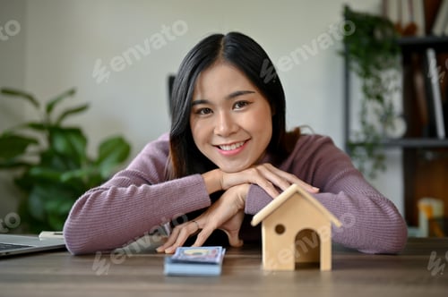 Preview: Home investment concept, young Asian girl with house model