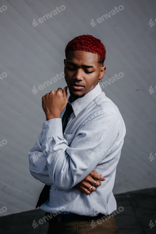 Preview: Portrait of a young Latin American man posing in executive clothes on gray background