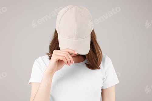 Preview: Young woman wearing stylish beige baseball hat on light grey background