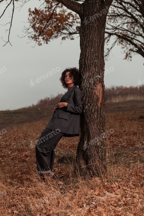 Preview: Beautiful Girl With Curly Hair In A Stylish Suit Walks Against The Backdrop Of A Beautiful Landscape