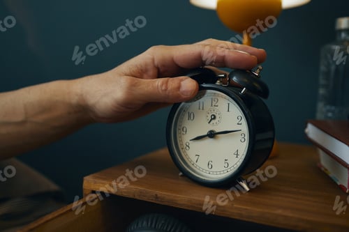 Preview: Hand Reaching for Alarm Clock at Bedside Table