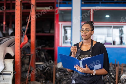 Preview: woman African American warehouse inspector wear spectacles crossed arms holding clipboard