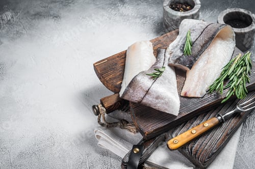 Preview: Haddock fish fillet, raw seafood meat on wooden board with herbs. White background.
