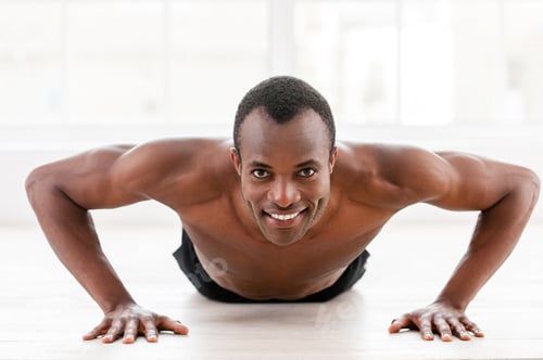 Preview: Man doing push-ups. Young muscular African man doing push-ups and looking at camera