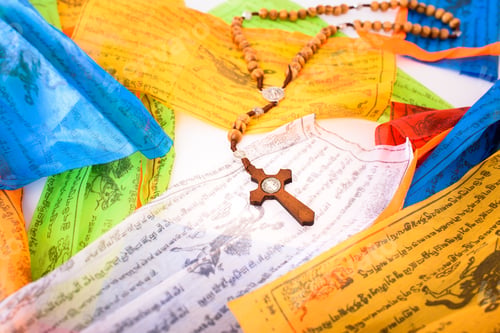 Preview: Catholic cross on colorful Tibetan Sanskrit banners with religious prayers