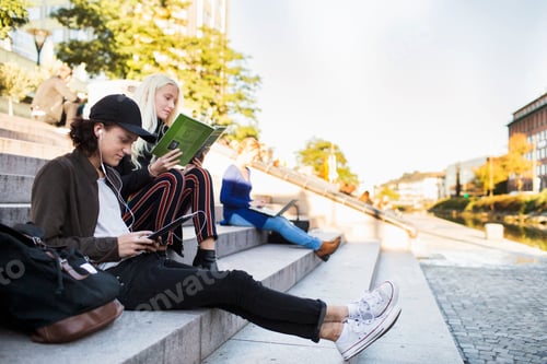 Preview: Teenage friends sitting and relaxing on steps