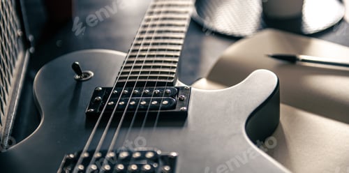 Preview: Close-up, electric guitar and notepad, concept of musical creativity.