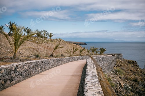 Preview: Scenic view of a winding road leading to a beautiful coastal area with lush palm trees
