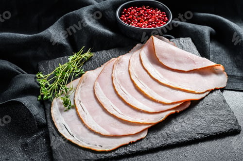 Preview: Slices of pork ham with thyme. Organic meat. Black background. Top view.