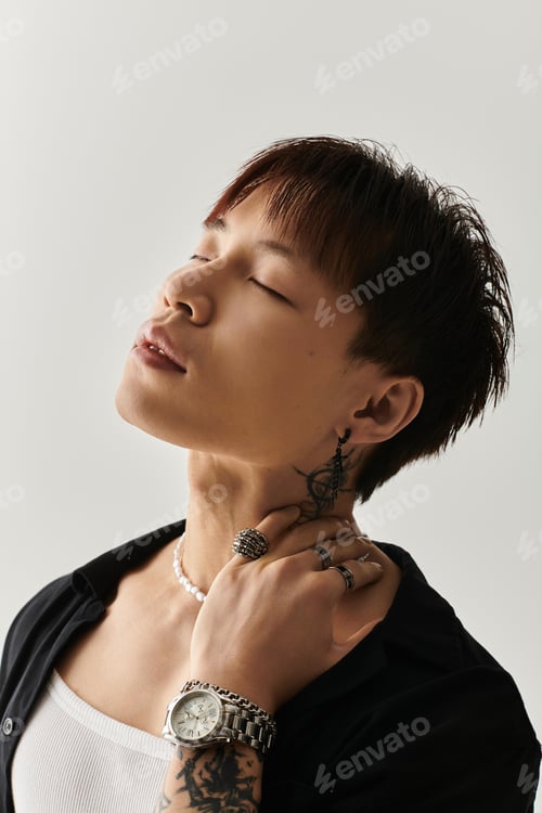 Preview: Stylish young Asian man showcasing modern elegance with accessories and expressive pose