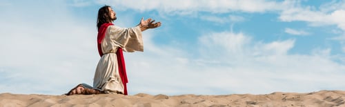 Preview: panoramic shot of jesus praying on knees in desert against sky