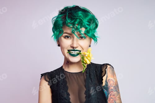 Preview: Woman with creative green coloring hair and makeup, toxic strands of hair. Bright color curly hair