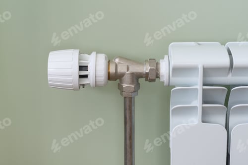 Preview: Heating white radiator in the apartment, the thermostat regulates the temperature.