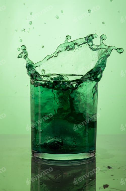 Preview: Vertical shot of a green cocktail splash on a green background