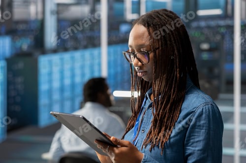 Preview: Engineer in server room using tablet to implement data backup solutions