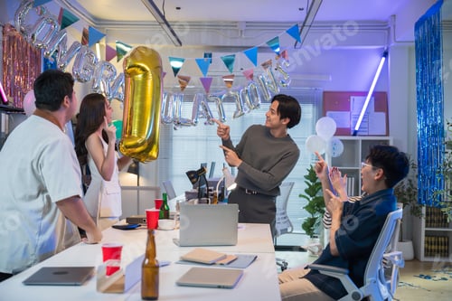 Preview: Asian sales team celebrating record-breaking success in modern office party