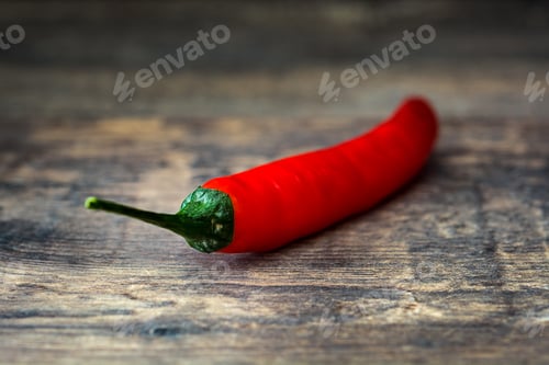 Preview: Fresh red chili pepper lying on rustic wooden table