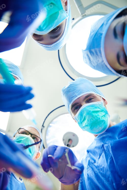 Preview: Low angle view of operating surgeons