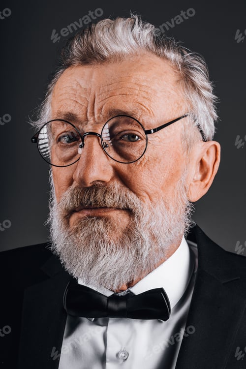 Preview: Closeup portrait of confident mature man in tuxedo isolated on black background