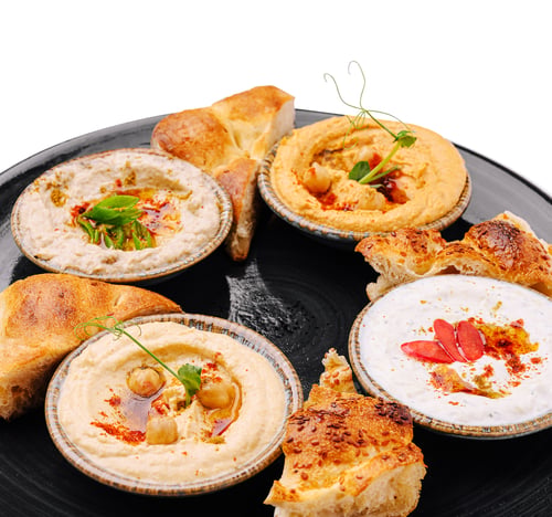 Preview: Delicious spread of hummus and bread served on a black plate