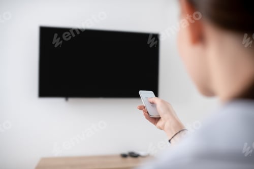 Preview: Female turning on the wall-mounted plasma TV