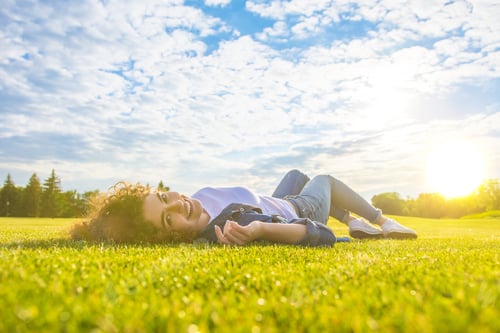 Preview: The cute woman lay on the grass against the background of the sunshine