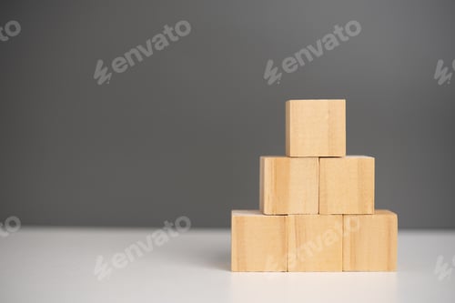 Preview: hand holding cube wood block blank on background. copy space