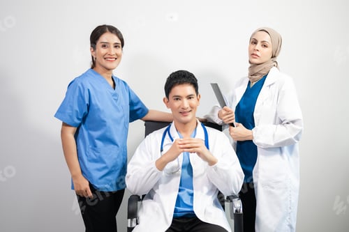 Preview: Successful team of medical doctors looking at camera and smiling while standin. Health, professional