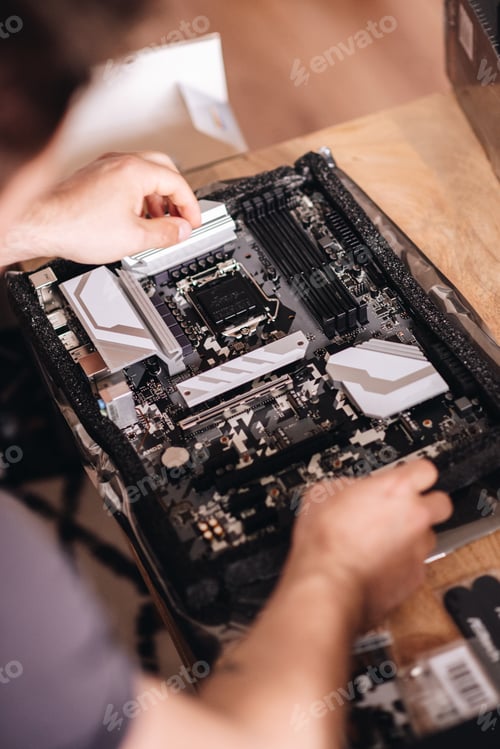 Preview: Vertical shot of the hands of a technician repairing the pc motherboard