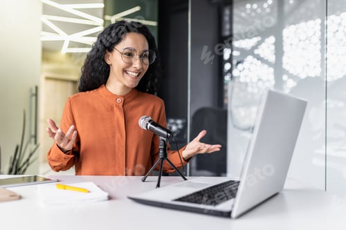 Preview: Successful Latin American businesswoman blogger recording online video podcast inside modern office