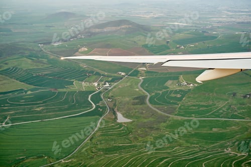 Preview: High above the ground. High angle shot of the views from an airplane window.