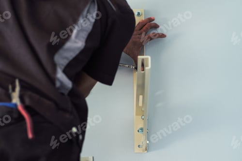 Preview: Selective focus on the hand of workman installing the steel support on the wall