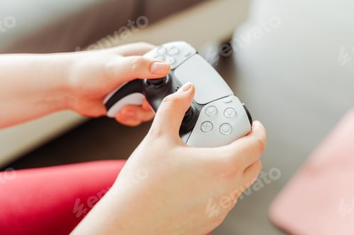 Preview: Closeup, female gamer holding joystick, playing video game in apartment, home, selective focus