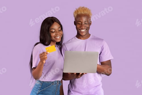 Preview: Online shopping. Young black couple using credit card and laptop to make purchase on web over lilac