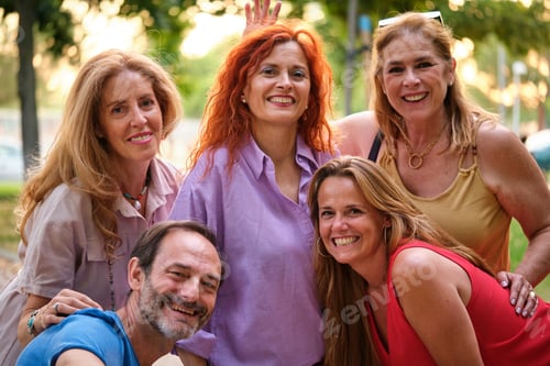 Visualização: Cinco adultos maduros tirando uma selfie e se divertindo em um parque.