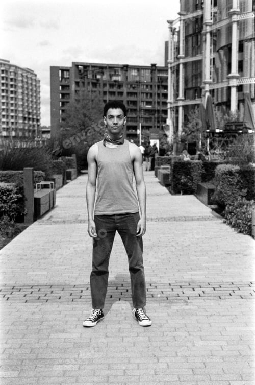 Preview: Young man standing in a city park, wearing casual clothes, grainy monochrome analog photography