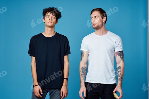 Preview: two men in t-shirts on a blue background and pants chatting friends