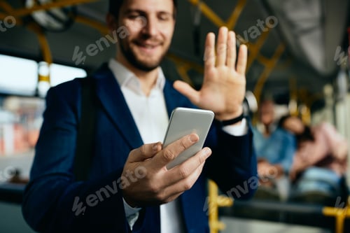 Preview: Close-up of businessman having video call over cell phone while commuting by bus.