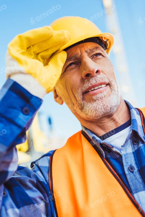 Preview: Worker in reflective vest and hardhat at construction site