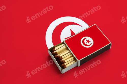 Preview: Tunisia flag is shown in an open matchbox, which is filled with matches and lies on a large flag.