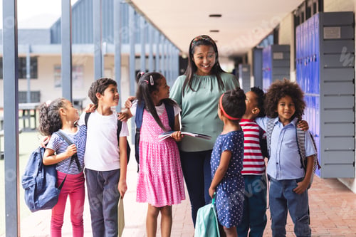 Preview: A middle-aged African American teacher with six diverse children outdoors at school