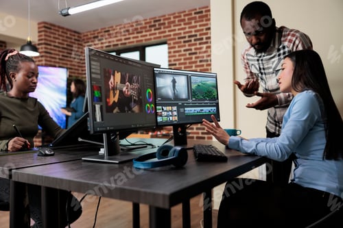 Preview: Footage editing specialist using multi monitor workstation to improve frames quality.